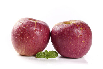 Obraz premium Fresh Red Apples with Water Droplets and Mint Leaves on White Background