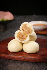Fototapeta premium Traditional Chinese Steamed Dumplings with Meat Filling on Wooden Serving Board