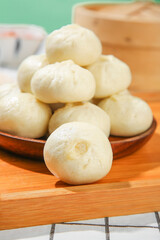 Fototapeta premium Fresh Steamed Chinese Buns on Wooden Plate - Traditional Asian Breakfast Dumplings