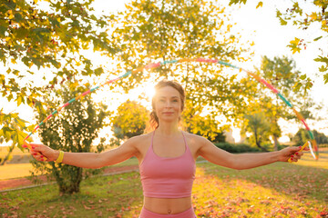 Naklejka premium Fit sportswoman jump rope outdoors in spring park