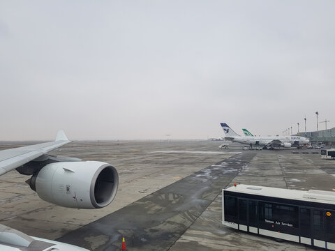 Tehran, Iran - December 25, 2016 - iran air and mahna air at park postion in ika imam khomeini international airport and the plane is landing