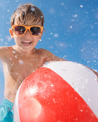 Fototapeta premium Happy child playing in waterpark. Kid having fun on summer vacation