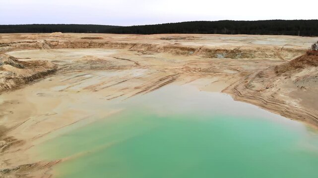 Aerial Perspective Of Tranquil Quarry Pond Displaying Jewel Tones Amidst Industrial And Natural Features. Media