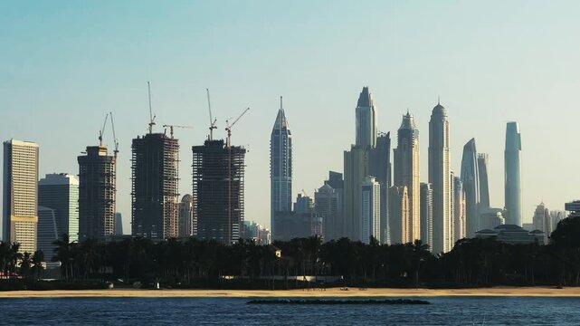 Jumeirah palm building construction site and Dubai Marina skyline background with skyscrapers at sunset, no logos