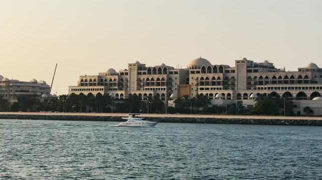 Luxury yacht sail along waterfront architecture at sunset with a yacht in Dubai, UAE