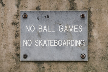 No Ball Games and No Skateboarding sign on urban concrete wall