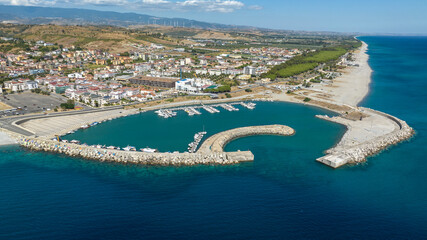 Aerial view of the Catanzaro Lido port, located on the Ionian coast of Calabria, Italy. Many small boats anchored in the clean, blue marina. It is a sunny summer morning. © Stefano Tammaro