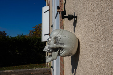 A skull decoration is attached to a wall outside