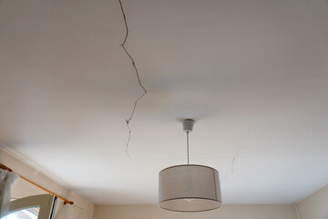 A crack is visible on the ceiling above a lamp