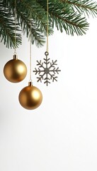 Obraz premium Pine branch with two gold baubles and silver snowflake ornament against white background. Holiday decoration, festive element, winter theme.