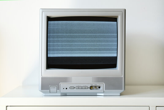 An old silver CRT TV with static on the screen.