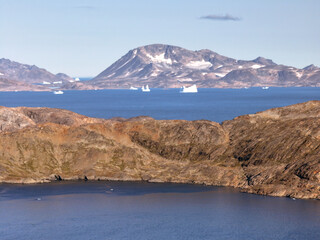 View of the waterfront infrastructure in Tasiilaq, Greenland. The clip shows the port area with shipping containers, fishing boats, and local housing, highlighting life in a remote Arctic community 