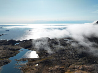 View of the waterfront infrastructure in Tasiilaq, Greenland. The clip shows the port area with shipping containers, fishing boats, and local housing, highlighting life in a remote Arctic community 