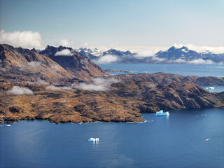View of the waterfront infrastructure in Tasiilaq, Greenland. The clip shows the port area with shipping containers, fishing boats, and local housing, highlighting life in a remote Arctic community 