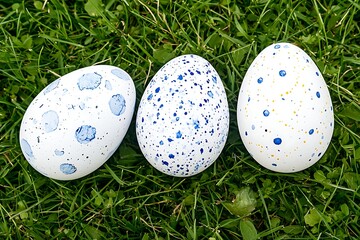 Colorful Hand-Painted Eggs on Grass with Unique Speckled Designs and Bright Accents