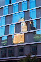 Historic Clock Tower Reflected in Modern Glass Office Building Windows