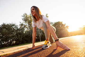 Naklejka premium Active woman in low start position getting ready for running