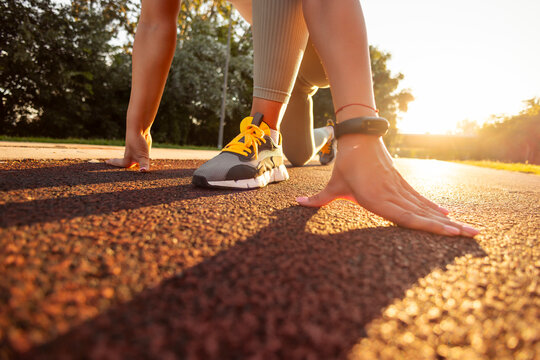 Detail of active woman in low start position getting ready for running