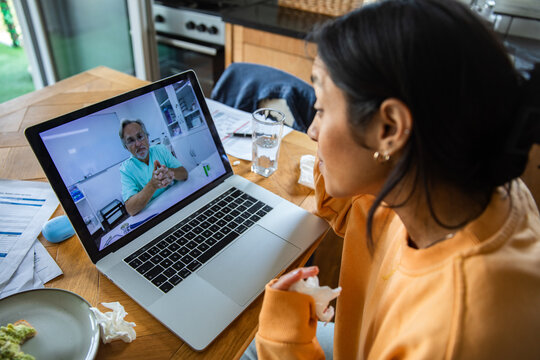 Sick woman consulting doctor via video call at home