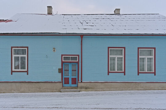 Old wooden house painted in blue and red on a winter day in the town of Rakvere, Estonia 