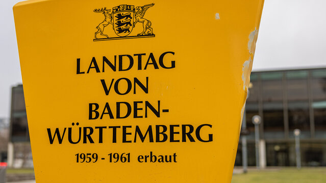 Detailansicht eines gelben Hinweisschilds mit der Aufschrift &bdquo;Landtag von Baden-W&uuml;rttemberg 1959&ndash;1961 erbaut&ldquo;. 