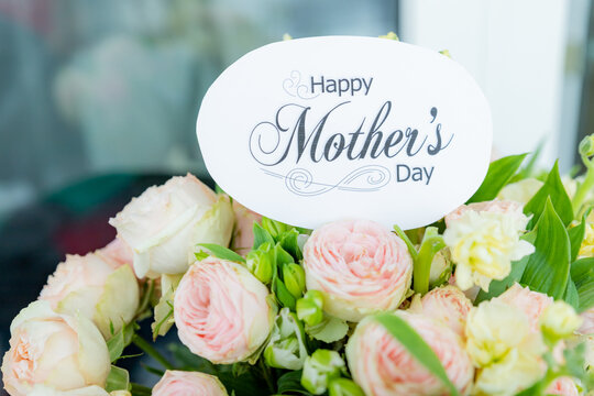 beautiful floral bouquet with a happy mother's day card , featuring pastel roses, lisianthus, and greenery.pale pink roses.pink blossom flower bouquet