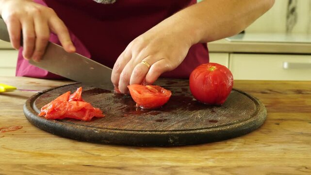 Woman cooking sauce with fresh tomato at the kitchen