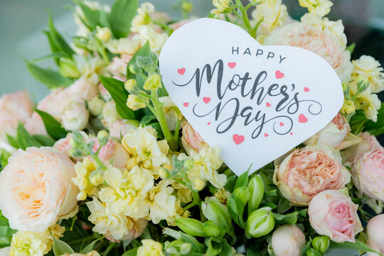 beautiful floral bouquet with a happy mother's day card , featuring pastel roses, lisianthus, and greenery.pale pink roses.pink blossom flower bouquet