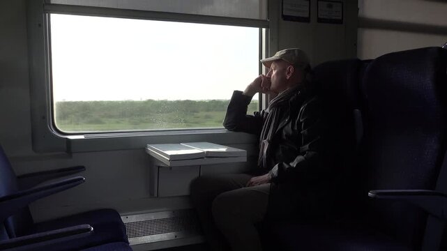 Mohammedia, Morocco A man sits looking out the window of a moving train between Casablanca and Rabat