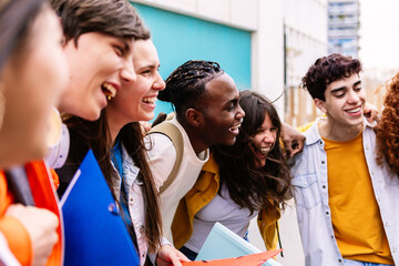 Happy diverse teenage students laughing standing together at high school campus