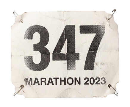 Runner bib number pinned to shirt paper sticker cutout.
