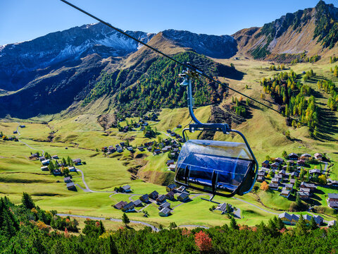 Vertical View of Enclosed Chairlift Seat Over Malbun Valley