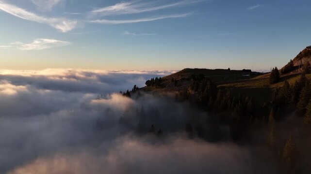 Aerial sunset view of mountain ridge silhouette againt sea of clouds