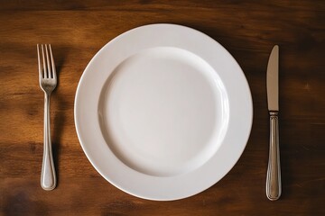 Empty plate rests on a wooden table next to a fork and knife in a simple dining setting during lunchtime
