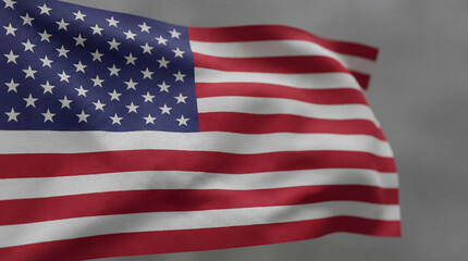 Obraz premium Majestic American flag gracefully unfurls its vibrant red, white, and blue fabric, stars shimmering, stripes flowing against a soft, cloudy grey sky