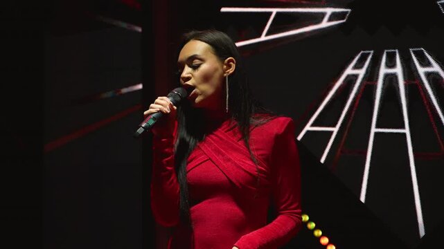 Female pop singer performing song on stage at live music concert