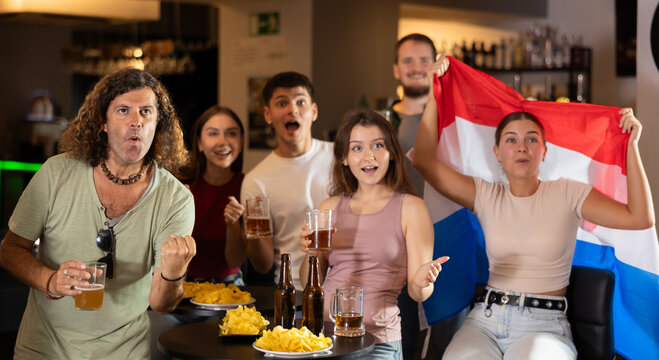 Fans of the Netherlands national team spend time in a bar, shouting chants, supporting their favorite team