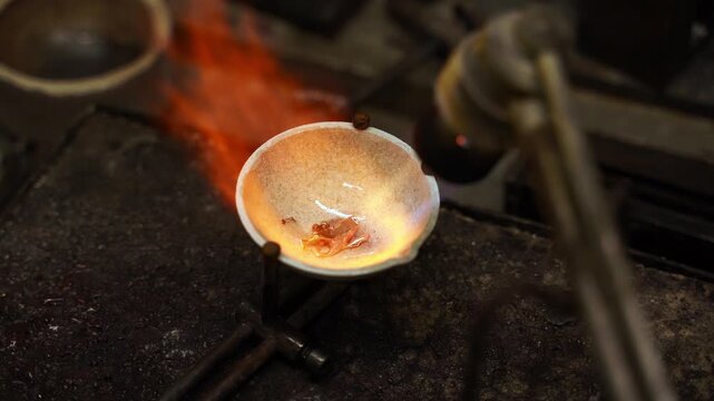 Jeweler melting gold with a gas torch in a crucible 4k video. Manual gold melting using a torch before casting jewelry.