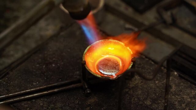 Jeweler melting silver in a crucible during the jewelry casting process 4k video. Molten silver in the crucible being heated to casting temperature as part of jewelry production.