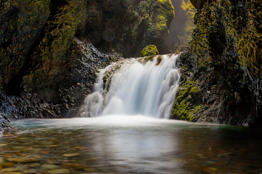 Nauthusafoss waterfall cascading inside the mossy walls of Nauthusagil ravine, Iceland