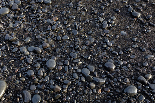 Black basalt stones on volcanic sand at Reynisfjara beach in Iceland