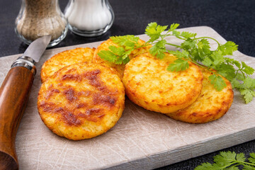 R&ouml;sti de pommes de terre dor&eacute; servi sur planche en bois