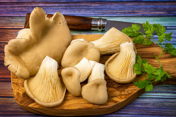 Pleurotes fra&icirc;ches sur planche en bois avec persil