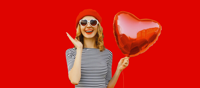 Portrait of happy cheerful smiling woman with red heart shaped balloon
