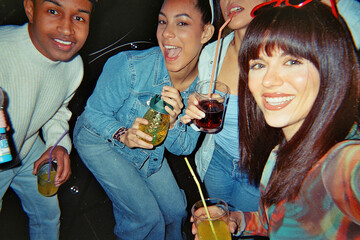 Diverse friends enjoying drinks at a retro night party © unai