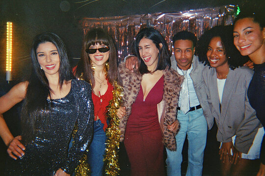 Diverse friends enjoying fun party with retro analog camera vibe