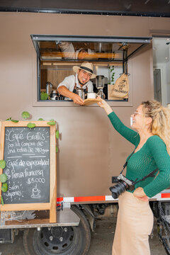 Coffee truck serving customer from motorhome window