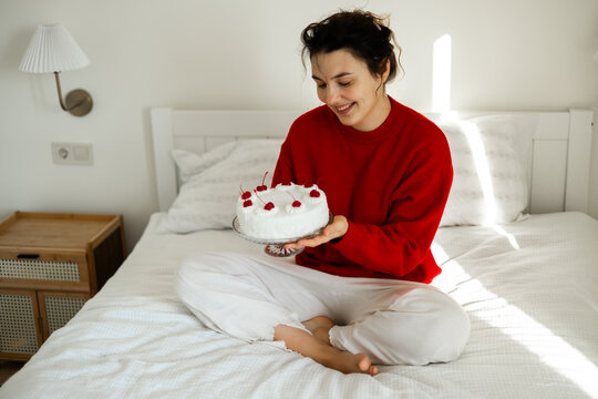 Woman holding cake with cherries and coconut flakes