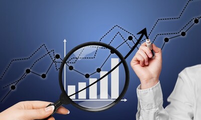 A magnifying glass over abstract financial chart,