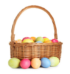 Fototapeta premium Painted Easter eggs in wicker basket isolated on white